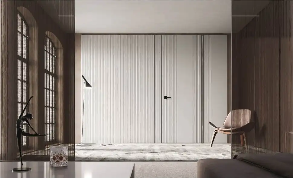 White full-height paneling with a flush door in a room with arched windows