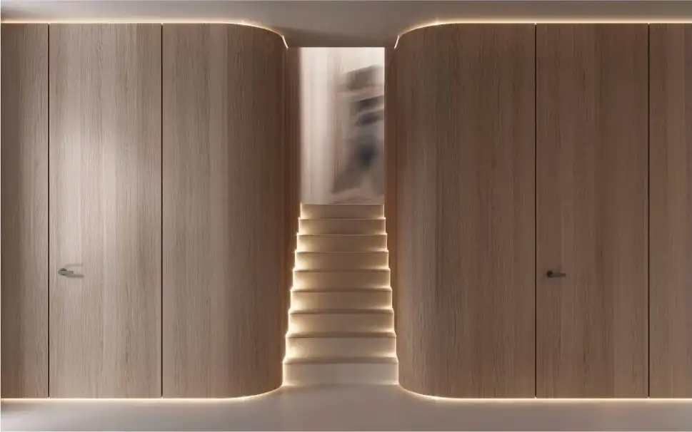 Curved walnut paneling wrapping a staircase with lit treads and a flush door