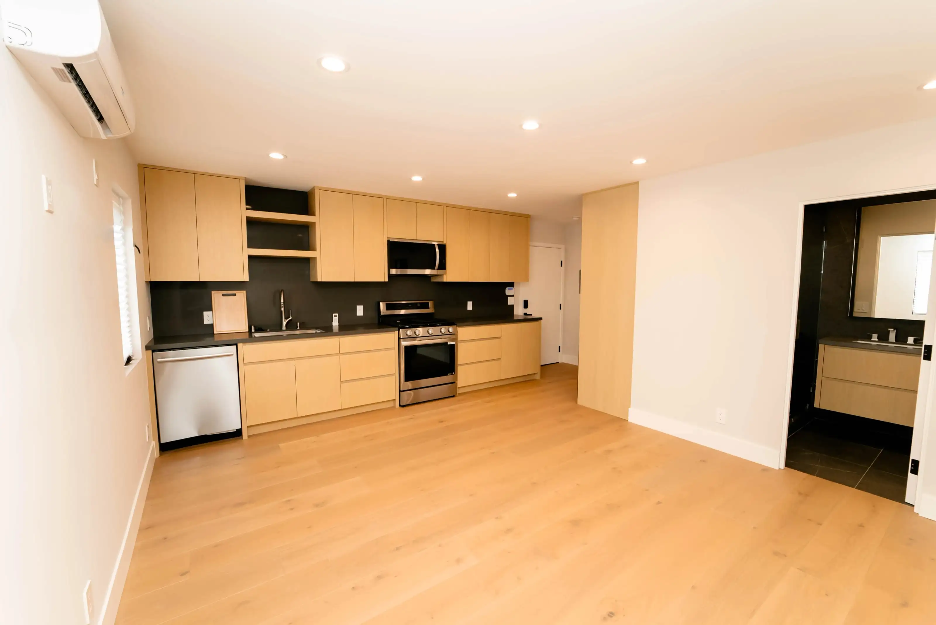 Contemporary kitchen renovation with flat-panel wood cabinets, built-in oven, and dishwasher – kitchen remodel San Jose.