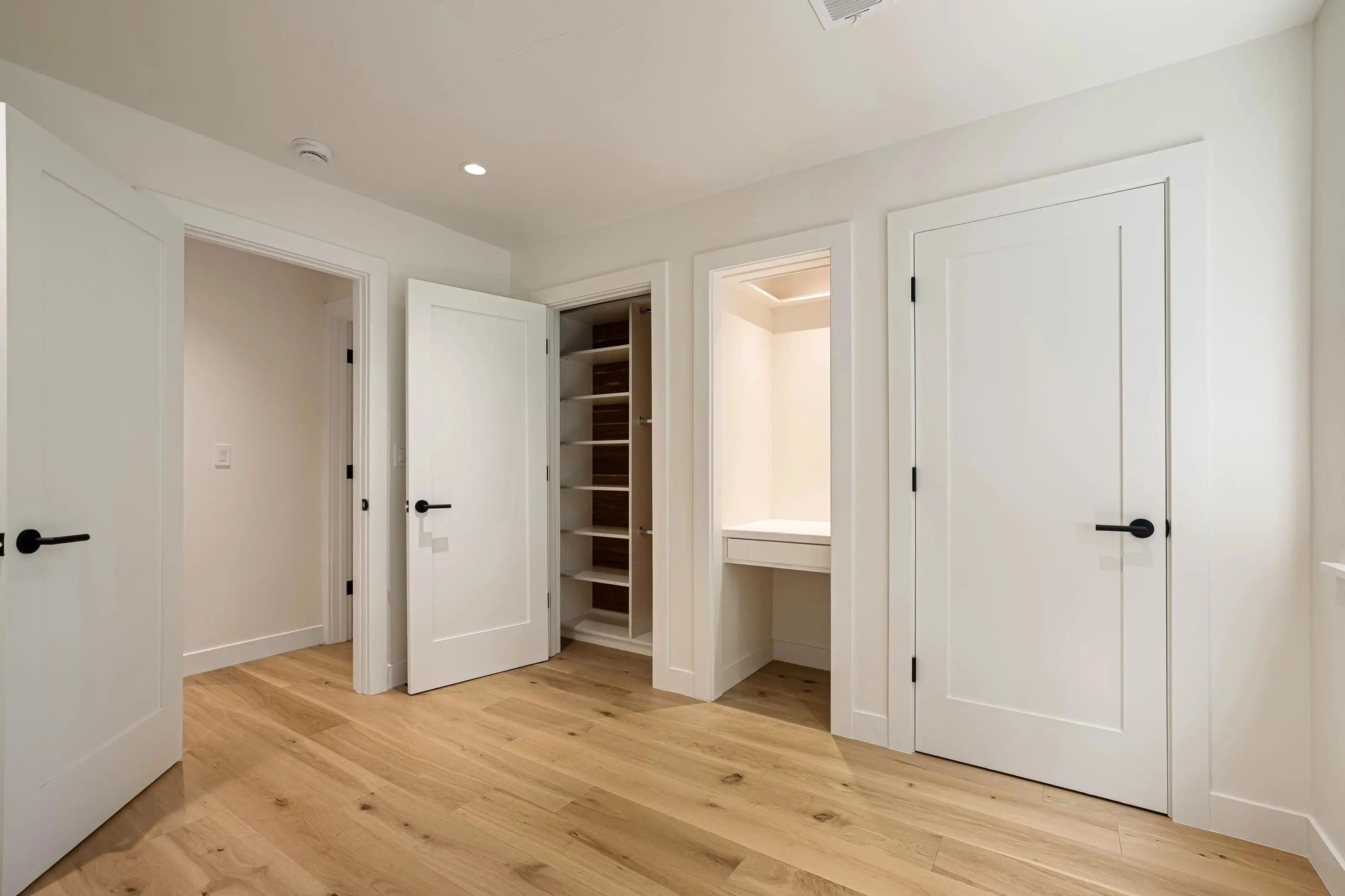 Bedroom remodel in San Jose with built-in closet, white shaker doors, and oak wood flooring for a clean modern finish.