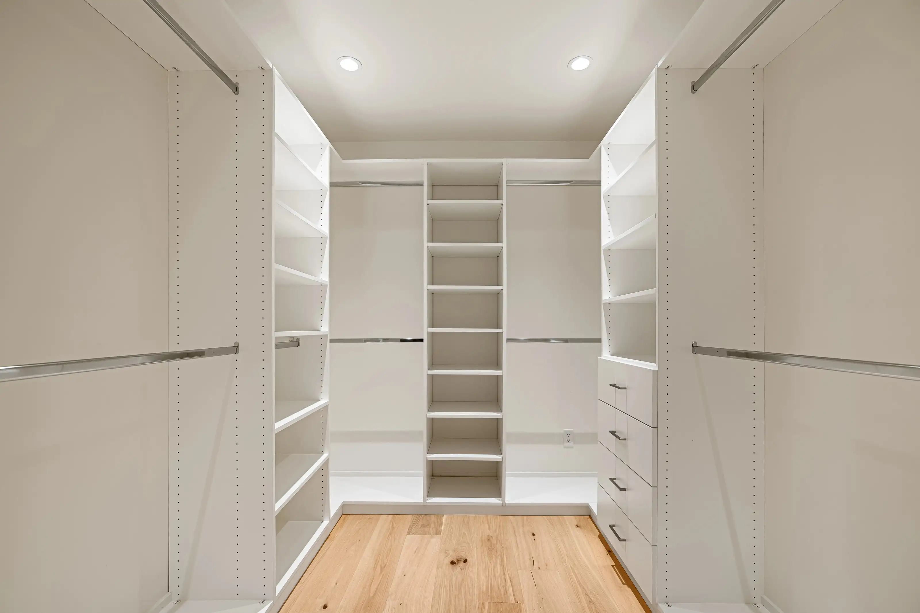 Spacious custom walk-in closet remodel in San Jose with built-in shelves, drawers, and LED ceiling lighting.