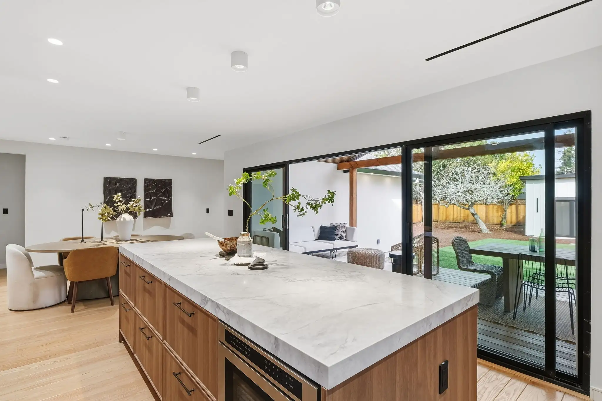 Kitchen remodel with marble island countertop, wood cabinets, and sliding glass doors opening to covered outdoor patio